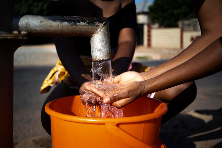 african-woman-pouring-water-recipient-outdoors_23-2149021910
